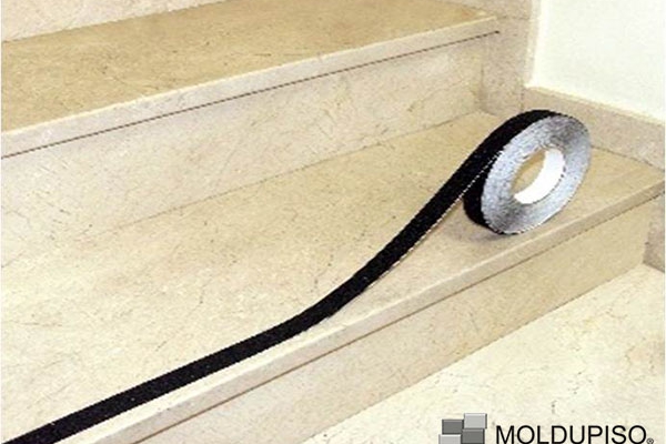 Colocación de cinta antiderrapante negra en rollo en escalera interior color beige