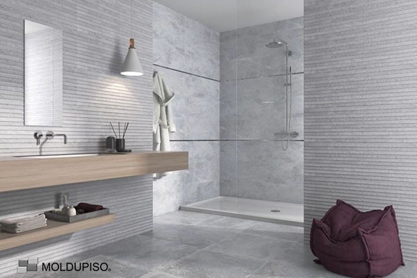 Listelo de aluminio de 8mm en baño minimalista, moderno elegante con pared color gris con regadera con puerta de cristal y lavabo de madera con moldura de aluminio