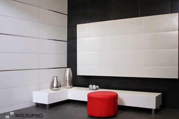 Listelo de aluminio en paredes en sala color blanco con taburete rojo y muebles de aluminio con molduras de aluminio