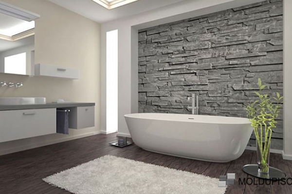 Zoclo de aluminio en baño moderno y elegante con pared de piedra y bañera con moldura de aluminio